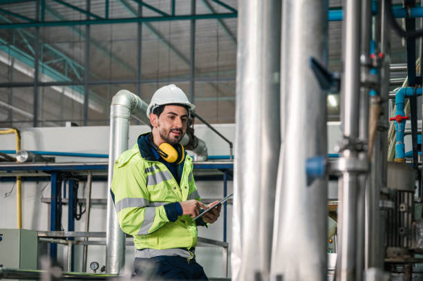 istock Caucasian technician engineer man in uniform with tablet checking and control boiler tanks and liquid pipeline in production line at factory 1370526421
