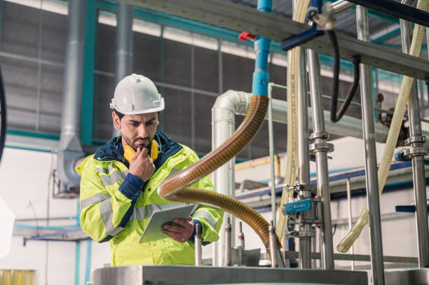 Caucasian technician engineer man in uniform with tablet checking and control boiler tanks and liquid pipeline in production line at factory Caucasian technician engineer man in uniform with tablet checking and control boiler tanks and liquid pipeline in chemical factory production line oil pump petroleum equipment development stock pictures, royalty-free photos & images