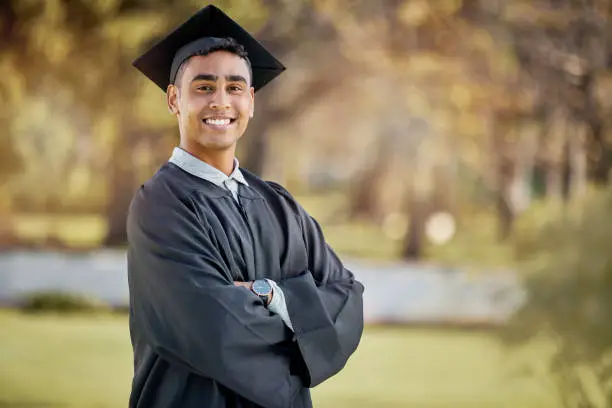 Photo of Portrait of a young man standing with his arms crossed on graduation day