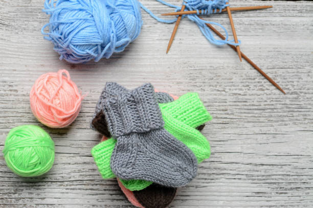 istock Messy knitters table, yarn and small baby socks on it 1370530113