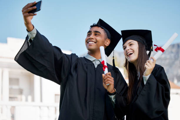 istock Shot of two young students taking selfies on graduation day 1370530558