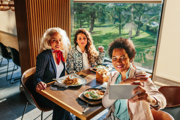 istock Three businesswomen taking selfie at restaurant 1370531321