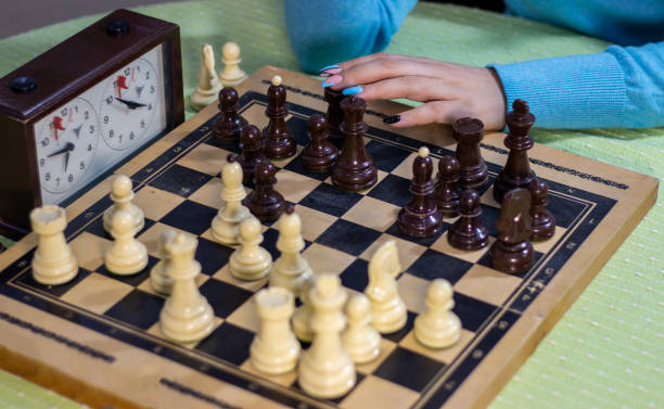 gioco degli scacchi. ragazza adolescente che gioca a scacchi. - clock time clock hand urgency foto e immagini stock