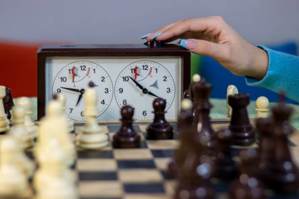 Chess game. Teenager girl playing chess. Hand of teenager girl pressing a button on the chess clock chess timer stock pictures, royalty-free photos & images