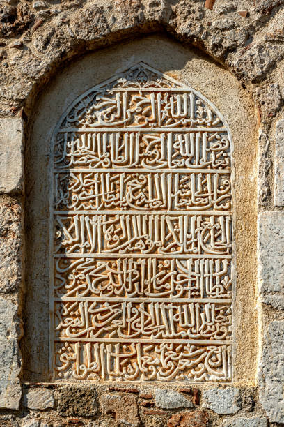 inscrição cortada em escrita árabe na parede do minarete yivli, antalya, que fala sobre a reforma da mesquita no século xiv - period costume fotos - fotografias e filmes do acervo