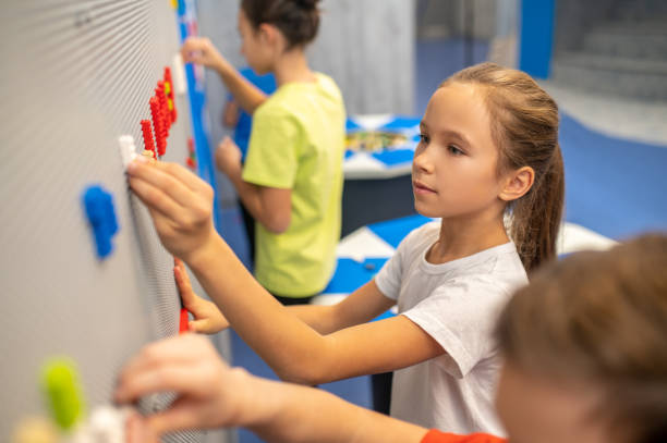 istock Girl attaching toy bricks piece to wall 1370536949