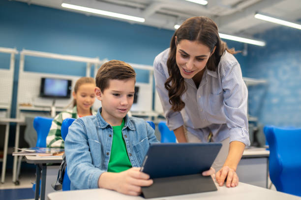 istock Woman looking into tablet of student boy 1370537095