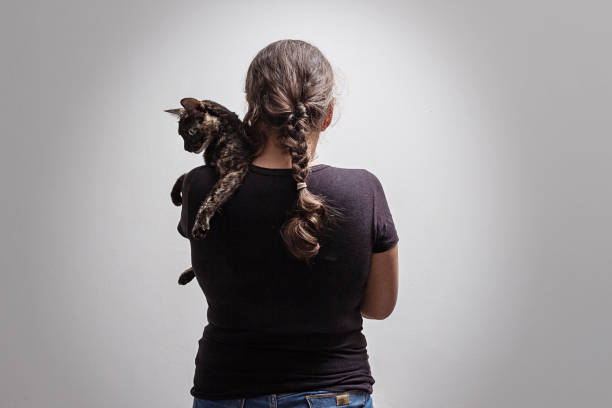 Goiânia, Goias, Brazil – February 14, 2022: A woman on her back with a carey cat on her lap.
