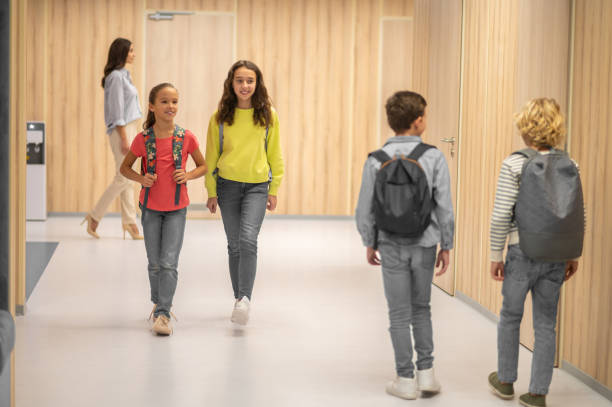 istock Girls looking at boys walking towards them 1370537214