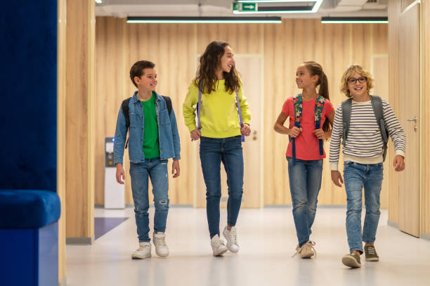 istock Schoolchildren with backpacks walking in corridor 1370537216