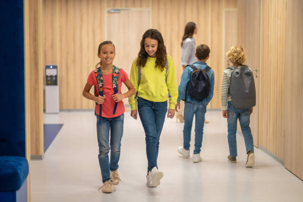 istock Girls walking and boys behind with backs to camera 1370537221