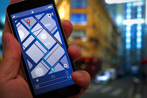 Close up of Tourist using GPS map navigation on smartphone application screen for direction to destination address in the city with travel and technology concept.