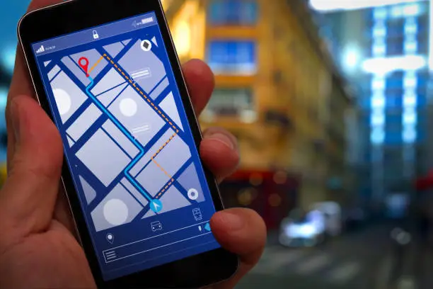Close up of Tourist using GPS map navigation on smartphone application screen for direction to destination address in the city with travel and technology concept.