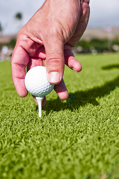 istock Golfer tees up golf ball on grass 137054240