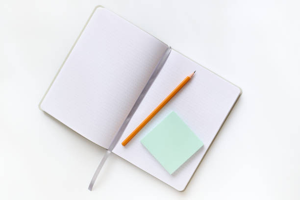 Open business diary and pencil with top view on light background table