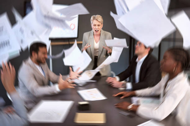 書類が落ちているオフィスでの会議中に怒って叫ぶシニアビジネスウーマンのショット - businesswoman frustration rudeness business ストックフォトと画像
