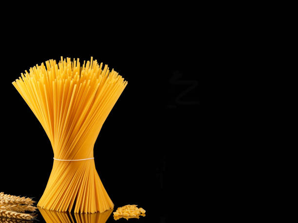 istock Spaghetti collection isolated on dark background with copy space. Whole grain pasta and spaghetti - shell on a dark mirrored table, ears of wheat nearby. Cooking concept, close-up 1370547976