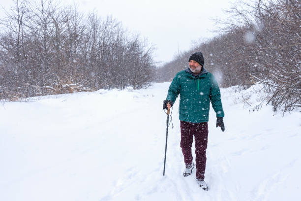 An active senior man winter hiking in the snow.