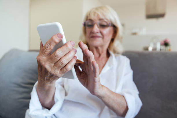 istock Mature woman in eyeglasses using mobile phone 1370548156