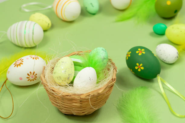 istock Easter nest with eggs and feathers on a green background close-up. Minimal concept. 1370549058