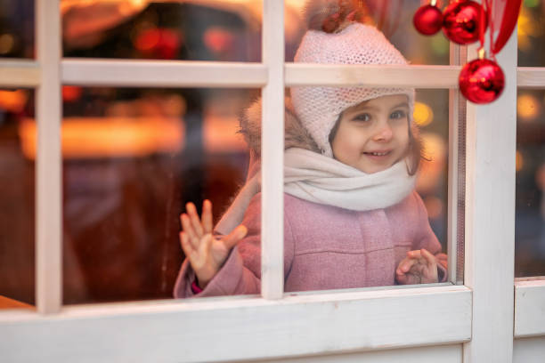 istock little girl looking out the window 1370549629