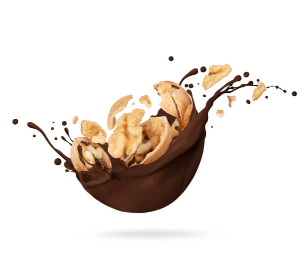 istock Dried crushed walnuts in chocolate splashes isolated on white background 1370550236