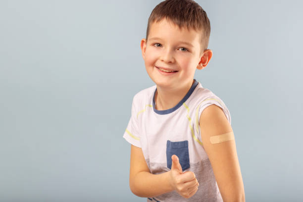istock Vaccinated boy gesturing with thumbs up, showing hand with plaster cast after injection of coronavirus vaccine. Start of vaccination campaign for children and teenagers. Successful Covid-19 vaccination 1370550608