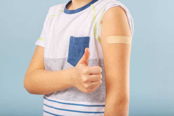 istock Vaccinated boy gesturing with thumbs up, showing hand with plaster cast after injection of coronavirus vaccine. Start of vaccination campaign for children and teenagers. Successful Covid-19 vaccination 1370550649