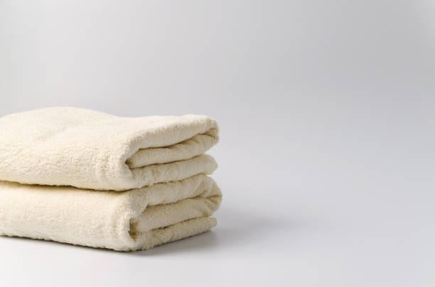 istock A stack of clean white towels on a white background with a place to demonstrate shampoo, cosmetics, soap 1370558705