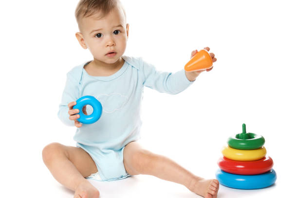 istock Little boy in romper sitting and playing with plastic toy. 1370560112