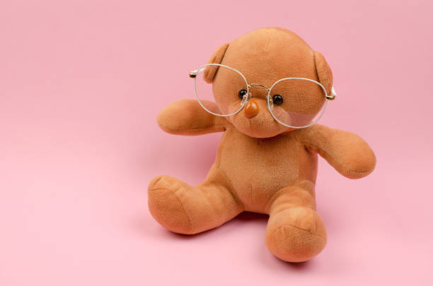 istock Teddy bear in glasses for vision on a pink background 1370560286
