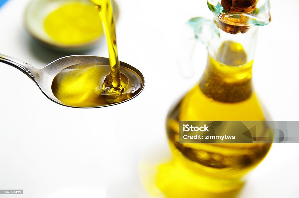 olive oil olive oil being poured into a spoon Measuring Stock Photo