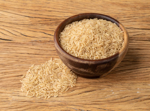 istock Raw brown whole rice in a bowl over wooden table 1370563601