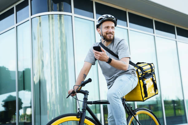 istock Express delivery courier with insulated bag holding phone on bicycle. 1370566632