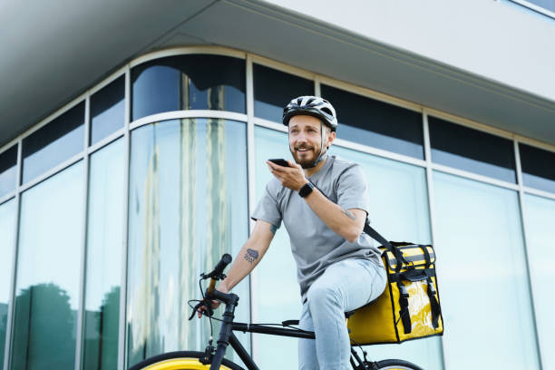 istock Express delivery courier with insulated bag holding phone on bicycle. 1370566665