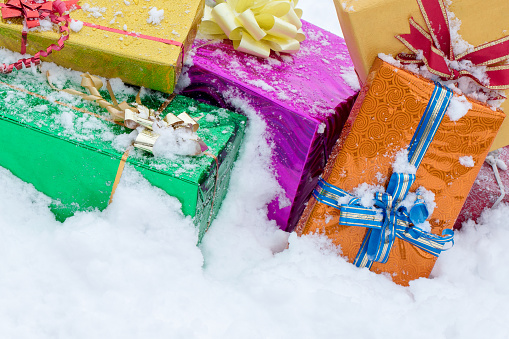 Multi colored Christmas presents (gift boxes) in the snow.