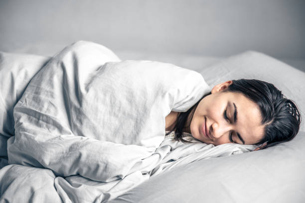 istock A beautiful young woman sleeps in a white bed. 1370570868