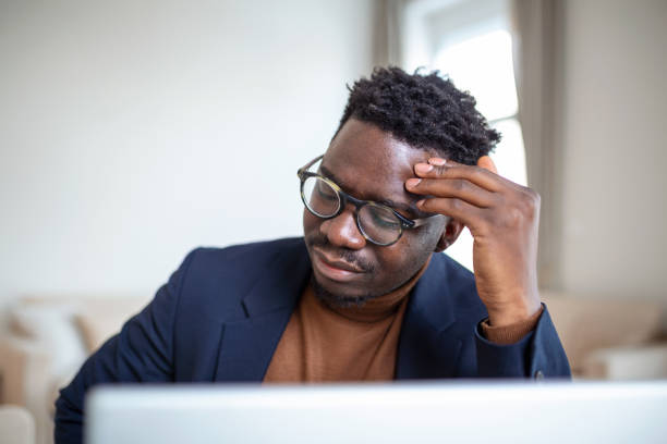 istock Stressed tired African American man touching temples, suffering from headache after long hours work, overworked overwhelmed businessman sitting at desk, feeling unwell 1370571220