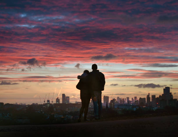 Spectacular red winter dawn over the city of London skyline with silhouettes of people gathering to watch the sunrise at this popular city viewpoint at Primrose Hill, London