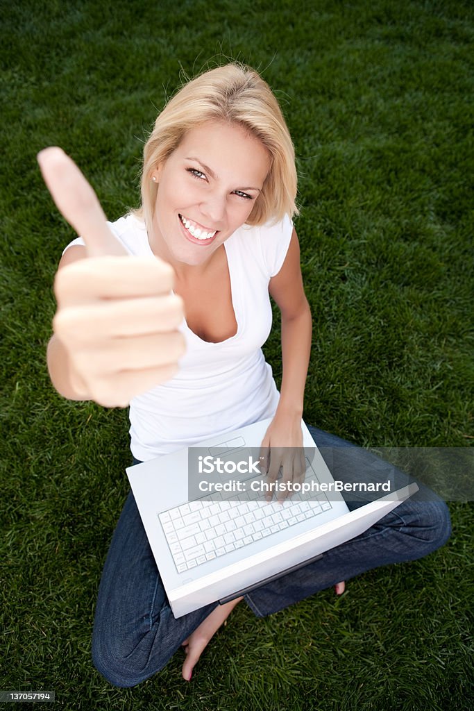 Jovem mulher usando um laptop com polegares para cima - Foto de stock de Sinal Afirmativo royalty-free