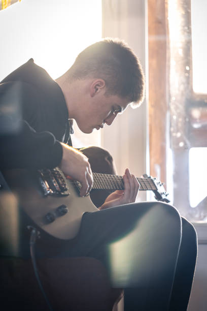 istock A young guy plays the electric guitar in his room. 1370572224