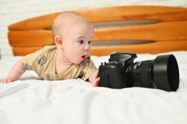 istock small child or baby boy on a white bed with a modern camera 1370573322