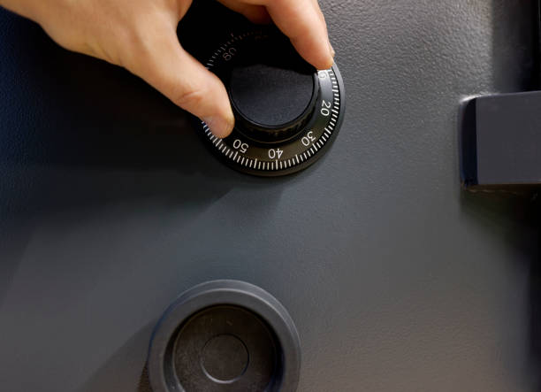 istock a man's hand dials a code on the limb of the safe by rotating it. 1370573580