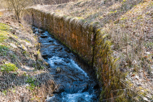 istock Long mountain stream next to mountain trail with high wall next to stream 1370574471