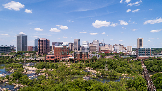 Aerial skyline of Downtown Richmond, Virginia. The distant view over the James River and surrounding parks and wooden natural areas. Extra-large, high-resolution stitched panorama.
