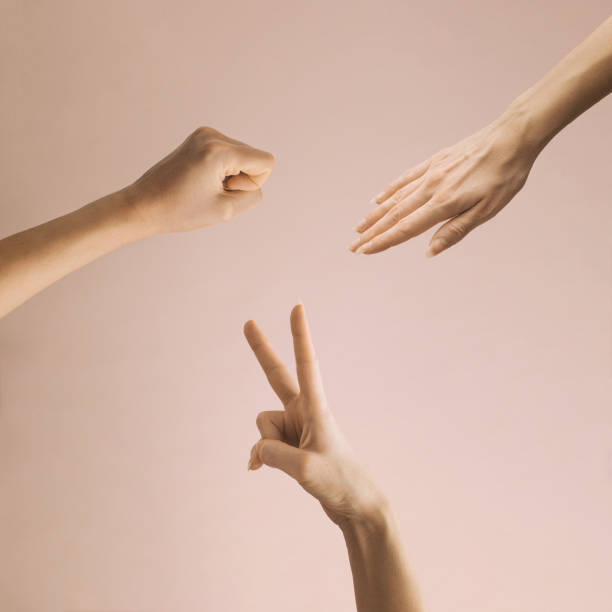 silhouette of hands gesture for rock paper scissor game, isolated on pink background. - thumb stones imagens e fotografias de stock