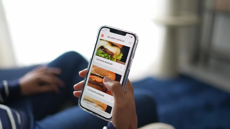 Happy young couple ordering food online with smartphone at home