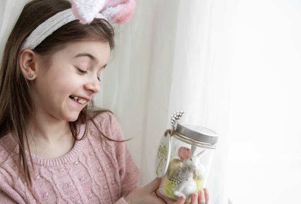istock Easter background with a girl in bunny ears and decor, copy space. 1370579203