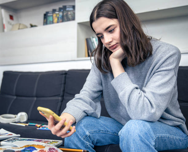 istock A young woman learns to draw using a video in a smartphone. 1370582272