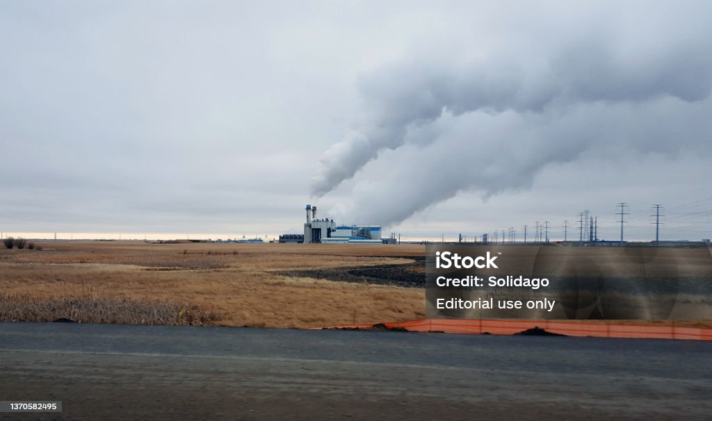 Industrial Pollution is Everywhere Calgary, Alberta, Canada- February 14,2022: Pollution in the air from industrial plant. Rural land on prairie. Non urban scene. Plumes of Smoke billowing from plant. Canada Stock Photo